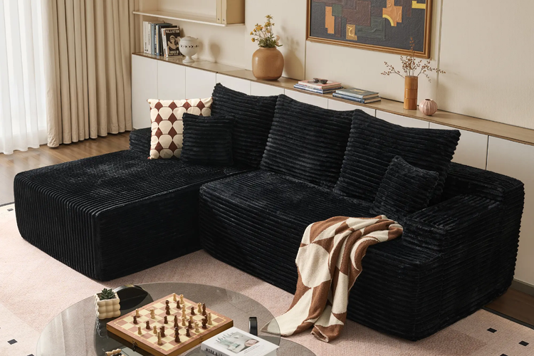 Black L-shaped corduroy couch near curtains in a room styling illustration