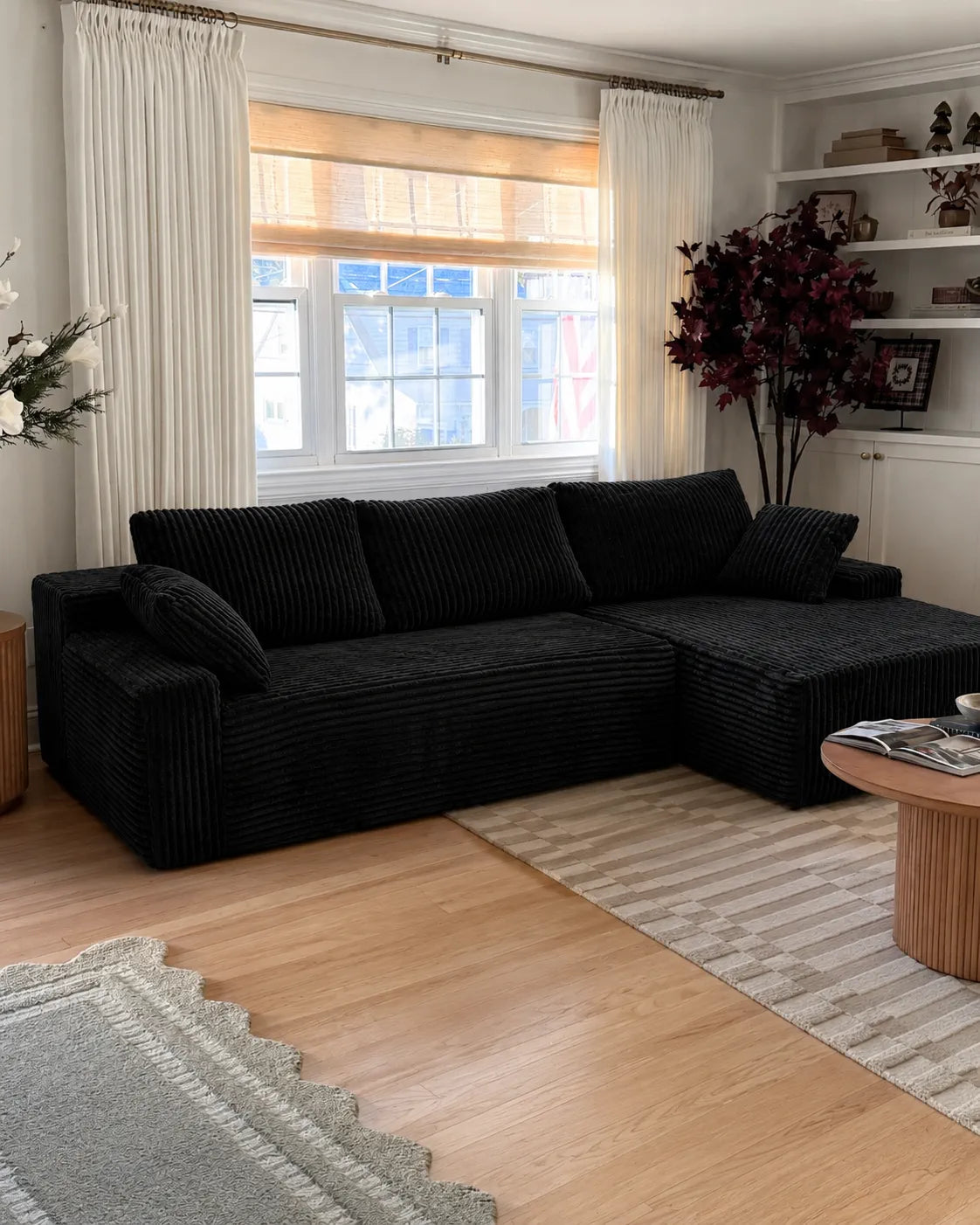 Black L-shaped couch styled for relaxed seating